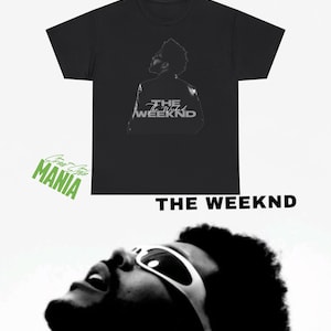 May include: A black short-sleeved t-shirt featuring a graphic print of a person wearing sunglasses looking upward. The text THE WEEKND is printed in white on the shirt and also appears in bold black text below the garment.