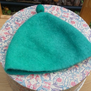 May include: A bright green wool beret with a small pompom on top.