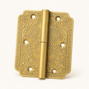 May include: A rectangular brass hinge featuring an embossed design of bamboo and floral patterns. The border is decorated with a geometric Greek key motif. The hinge includes six circular screw holes and a central cylindrical barrel hinge pin.