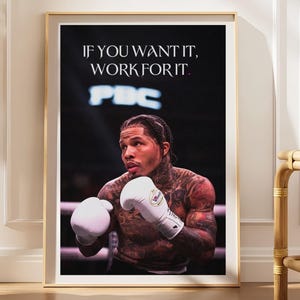 May include: A framed poster featuring a shirtless boxer with tattoos wearing white boxing gloves in a ring. The text IF YOU WANT IT, WORK FOR IT is printed in white at the top. The background shows a dark arena with a blurred PBC logo in the distance.