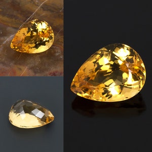 May include: Three pear-shaped gemstones with a golden yellow color. The gemstones are faceted and have a high shine.