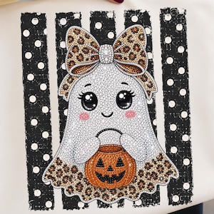 Peut inclure: Un sweat-shirt blanc avec un motif de fantôme de dessin animé aux grands yeux noirs, joues roses et sourire. Le fantôme porte un nœud à imprimé léopard et tient un seau citrouille orange. Le fond présente des rayures verticales noires à pois blancs.