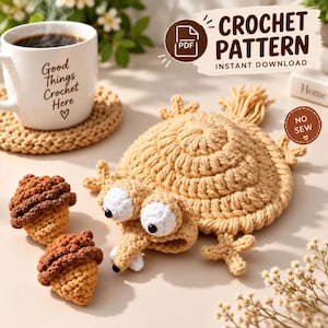 Op de afbeelding: Een haakpatroon PDF instant download met een beige gehaakt eekhoornachtig wezen met grote witte ogen en twee kleine bruin met beige gehaakte eikels. Een witte mok met de tekst Good Things Crochet Here staat op een beige onderzetter.