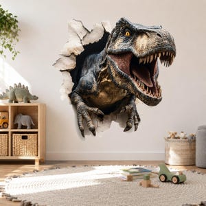 May include: A wall decal featuring a realistic, three-dimensional effect of a Tyrannosaurus Rex breaking through a white wall. The dinosaur has textured, dark brown and tan skin, sharp teeth, and yellow eyes, with its claws extended forward.