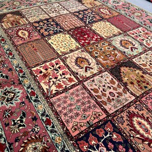 May include: A rectangular area rug featuring a patchwork design of various square panels. Each square displays intricate floral and botanical motifs in shades of pink, red, cream, navy blue, and gold. The rug has a wide, ornate floral border.