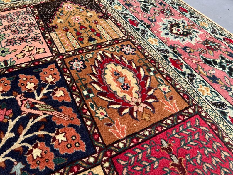 May include: A rectangular area rug featuring a patchwork design of various panels. The panels display intricate floral motifs, bird illustrations, and geometric patterns in vibrant shades of pink, navy blue, deep red, orange, and cream.
