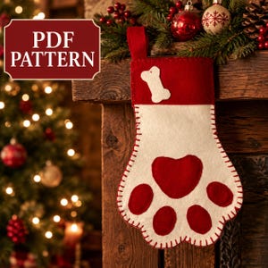 May include: A felt Christmas stocking shaped like a paw print with a red cuff featuring a white bone appliqué. The main body is white with a large red heart-shaped pad and four smaller red circular toe pads, all joined by visible red stitching.