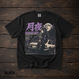 Könnte beinhalten: Ein schwarzes Kurzarm-T-Shirt mit einem Grafikdruck einer Person, die sich unter einem Vollmond an ein weißes Auto lehnt. Das Design enthält violetten japanischen Text, die Worte MOONLIGHT RACER und verschiedene technische Textelemente.