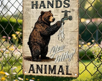 May include: A rectangular metal sign with a vintage newspaper background featuring a brown bear standing on its hind legs, reaching for a water faucet. The text reads WASH YOUR HANDS and You filthy ANIMAL in black and cursive lettering.