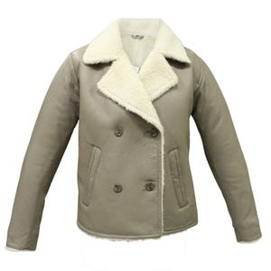 Puede incluir: Una chaqueta de doble botonadura en color topo apagado con un cuello ancho y muescas forrado de piel sintética color crema. La chaqueta incluye cuatro botones oscuros en la parte delantera, dos bolsillos verticales y mangas largas.