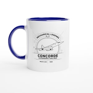 May include: A white ceramic mug with a dark blue handle and interior rim. The front features a black line drawing of the Concorde supersonic airliner, with the text "MECHANICAL LEGENDS No. 01 CONCORDE SUPERSONIC AIRLINER MACH 2.04 1969" printed below.