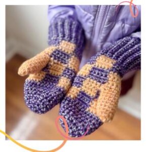 May include: A pair of crochet mittens featuring a checkered pattern in alternating purple and light orange yarn. The mittens have a ribbed cuff design and a textured stitch throughout, providing a thick and warm appearance for cold weather.