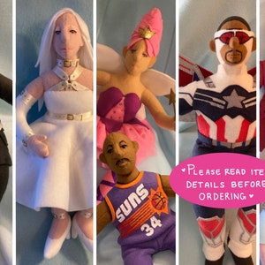 May include: A collection of handmade plush toys, including a figure wearing a black and white lightning bolt sweater, a white dress with a gold belt, a purple and pink dress with a crown, a blue and red superhero costume, and a brown and white colonial-style outfit. The text "Please read item details before ordering" is written in pink on a white background.