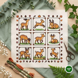 May include: A square piece of white Aida fabric featuring a cross-stitch pattern of nine individual squares, each containing a brown deer in various poses. The border is decorated with small autumn motifs like pumpkins, mushrooms, and acorns.