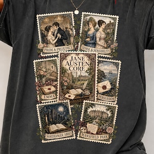 May include: A charcoal gray short-sleeve t-shirt featuring a graphic print of six postage stamp-style illustrations. The central stamp reads Jane Austen Core, surrounded by stamps labeled Pride & Prejudice, Sense & Sensibility, Emma, Persuasion, Northanger Abbey, and Mansfield Park, each depicting scenes from the novels.