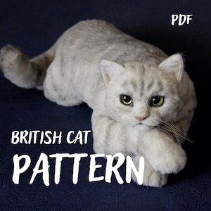 Peut inclure: Un chat en laine feutrée gris clair avec des rayures tabby gris foncé et des yeux jaune-vert brillants. Le chat est en position accroupie. Le texte PDF, BRITISH CAT et PATTERN est imprimé en blanc sur le fond sombre de l'image.