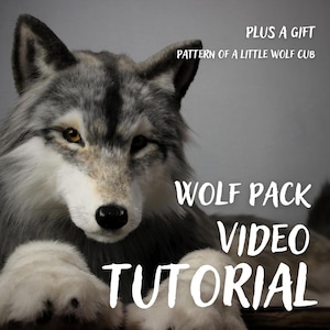 Op de afbeelding: Een realistische pluche wolf met grijze, witte en zwarte vacht, amberkleurige ogen en een zwarte neus. De tekst luidt: PLUS A GIFT PATTERN OF A LITTLE WOLF CUB en WOLF PACK VIDEO TUTORIAL. De wolf is vanaf de borst zichtbaar met voorpoten.