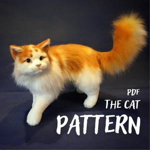 Może przedstawiać: Pluszowy kot z pomarańczowo-białym futrem, długim puszystym ogonem i spiczastymi uszami. Napis "PDF THE CAT PATTERN" widnieje białymi literami w prawym dolnym rogu, co wskazuje na cyfrowy przewodnik krawiecki do wykonania zabawki.