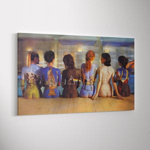 Op de afbeelding: Een rechthoekige canvasprint met zes personen die op een rij staan met hun rug naar de kijker toe. Hun lichamen zijn beschilderd met diverse artistieke ontwerpen, waaronder een prisma, een bakstenen muur en landschappen, tegen een zwembadachtergrond.