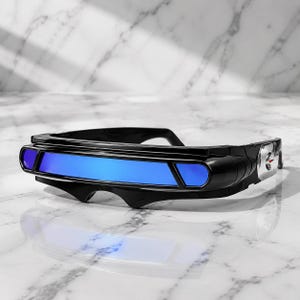 May include: Futuristic visor-style sunglasses featuring a sleek black frame and a single continuous blue reflective lens. The temples are accented with silver-toned metallic details, creating a bold, streamlined aesthetic for these wrap-around glasses.