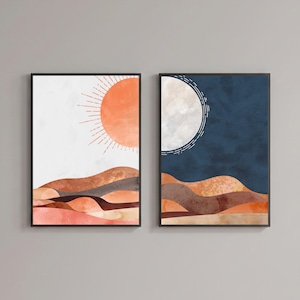 以下が含まれることがあります： 抽象的な風景を描いた2枚の額入りウォールアートプリント。左のプリントは、ピーチ、ブラウン、クリーム色の重なり合う丘の上に、光線を放つオレンジ色の太陽が描かれています。右のプリントは、濃い青色の空を背景にした白い月と、同様の丘が描かれています。
