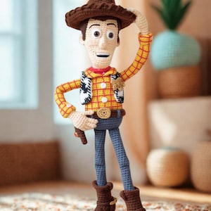 May include: A crocheted doll of a cowboy character wearing a brown hat, a yellow and red plaid shirt, a white and black cow-print vest, blue pants, and brown boots. The doll features a gold-colored sheriff badge and a belt buckle.