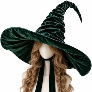 May include: A dark green velvet witch hat featuring a wide, flexible brim and a tall, pointed, ruched crown. The hat includes two long, matching green velvet ribbons attached at the base for securing the hat under the chin or styling.
