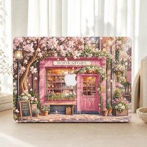 May include: A laptop skin featuring a pink bookstore storefront with a large tree covered in pink blossoms, a street lamp, and a small chalkboard sign that reads Good Books Brighter Days. The design incorporates a central cutout for an Apple logo.