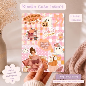 Könnte beinhalten: Ein rechteckiger Kindle-Hülleneinleger mit einem rosa-orangen Karomuster, verziert mit herbstlichen Motiven wie einem Geist mit Kürbis, Bücherstapeln, einem Kaffeebecher und einer lesenden Person, inklusive dem Text In my Kindle era.