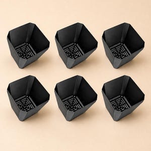 May include: A set of six black square-shaped plant pots arranged in two rows of three. Each pot features a faceted, angled rim and a base with a grid of drainage slots. The containers have a matte finish and a wide, open top design.