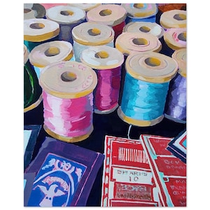 May include: An oil painting depicting a collection of colorful thread spools in shades of pink, blue, and green, arranged above several rectangular needle packets. The red needle packets feature white text including the words SHARPS 10.