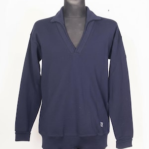 May include: A navy blue long-sleeved sweater with a V-neck collar. The sweater has a ribbed hem and cuffs. A small logo is visible on the lower left side. The sweater is displayed on a black mannequin.