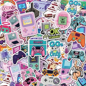 Può includere: Una collezione di adesivi in vinile con varie console per videogiochi, dispositivi portatili e controller in colori pastello e vivaci. I design includono testi come GAME OVER, GAMER, GGs ONLY e IT'S OK TO PLAY WITH YOURSELF.