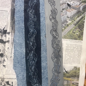 Könnte beinhalten: Ein rechteckiger Streifen aus blauem Jeansstoff mit einem weißen Druck eines um einen Ast gewickelten Schlangenmotivs, neben einem grauen rechteckigen Block, der dasselbe Schlangen- und Astdesign mit schwarzen Tintenumrissen zeigt.