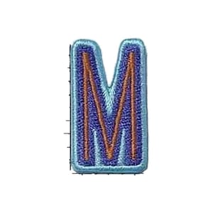 May include: An embroidered letter M patch featuring a dark purple center, a light blue border, and a thin copper-colored outline tracing the shape of the letter. The patch has a rectangular shape with rounded corners and a textured thread finish.