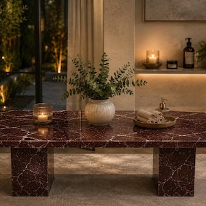 May include: A rectangular coffee table featuring a deep burgundy red surface with prominent white veining throughout. The table is supported by two thick, matching rectangular slab legs, creating a solid and cohesive appearance in the design.