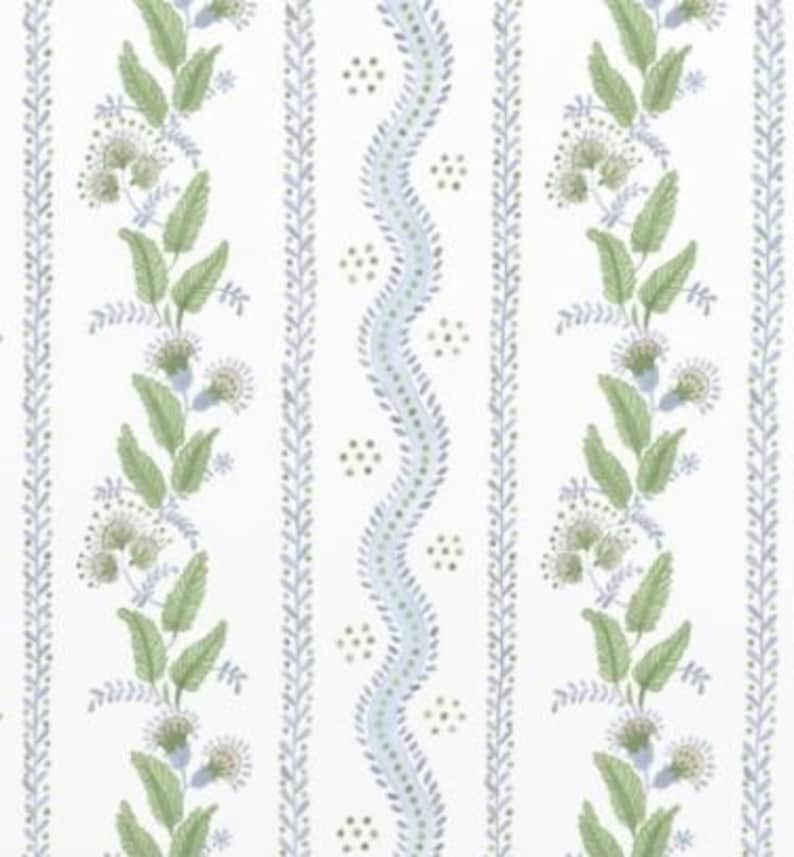 May include: A white background with a repeating pattern of green leaves, blue wavy lines, and small green dots. The pattern is in vertical stripes.