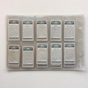 May include: A collection of vintage Wills Cigarettes Household Hints cards, presented in a clear plastic holder. Each card has text and a blue border. The cards are arranged in rows, offering household tips.