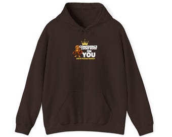 Puede incluir: Una sudadera con capucha de color marrón oscuro que presenta un gráfico en el pecho. El gráfico incluye una pequeña figura de dibujos animados, una corona amarilla y el texto blanco "CONFIDENCE LOOKS GOOD ON YOU" con el texto amarillo "SOLAR PLEXUS ENERGY" debajo.