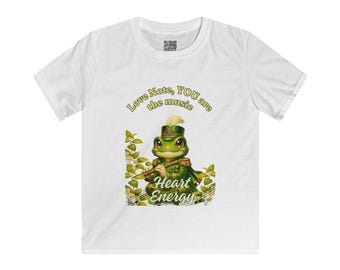 Puede incluir: Una camiseta blanca de manga corta con una rana verde que lleva un sombrero y uniforme de estilo militar mientras toca la flauta. El texto dice Love Note, YOU are the music y Heart Energy, rodeado de hojas verdes y notas musicales.