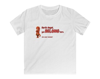 Puede incluir: Una camiseta blanca de manga corta con un gráfico de un pequeño personaje parecido a un dragón rojo. El texto dice: Earth Angel, you BELONG here. THE ROOT ENERGY. El diseño está centrado en la zona del pecho de la prenda.