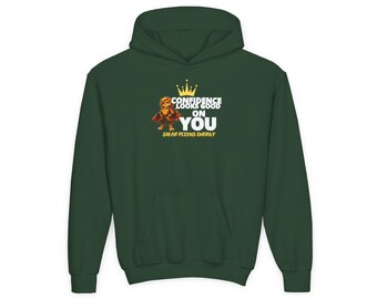 Puede incluir: Una sudadera con capucha de color verde oscuro que presenta un gráfico de un pequeño personaje con capa y una corona amarilla. El texto CONFIDENCE LOOKS GOOD ON YOU y SOLAR PLEXUS ENERGY aparece en letras blancas y amarillas en el pecho.