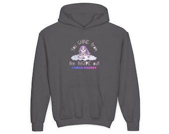 Puede incluir: Una sudadera con capucha de color gris carbón oscuro que presenta un gráfico de una pequeña criatura de pelo morado sentada sobre una nube. El texto dice: YOU SHINE FROM THE INSIDE OUT! CROWN ENERGY. El diseño incluye una estrella morada y azul.