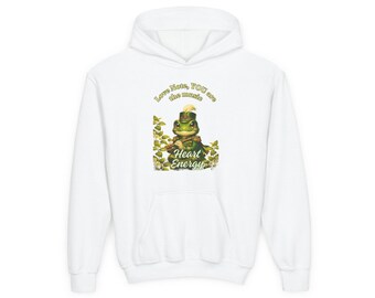 Puede incluir: Una sudadera con capucha blanca que presenta un gráfico de una rana verde con un sombrero de estilo militar tocando la flauta. El texto superior dice Love Note, YOU are the music y el inferior Heart Energy.