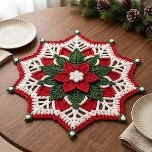 May include: A star-shaped crochet doily featuring a central red poinsettia flower with green leaves and a white center. The outer border is crafted in white and red yarn with small white accents at each point, creating a festive, intricate design.