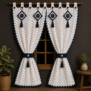 May include: A pair of off-white crochet curtains featuring a chevron pattern, dark navy blue scalloped edges, and matching tie-backs. Each curtain is adorned with four dark navy blue diamond-shaped motifs with tassels and circular buttons.