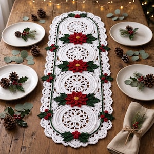 May include: A white crocheted table runner featuring circular lace patterns, decorated with red poinsettia flowers, green leaves, and small red berries. The runner is centered on a wooden surface with four white plates and pinecone accents.