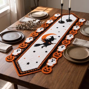 May include: A white crochet table runner featuring a central black silhouette of a witch on a broomstick against an orange crescent moon. The border is decorated with alternating orange jack-o'-lanterns and white ghosts, accented by black stars.