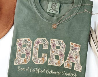 Camisetas BCBA con flores y colores cómodos, camiseta de analista de conducta certificado por la junta, camiseta de concienciación sobre el autismo, camiseta BCBA con fuente universitaria, regalo para el grupo BCBA