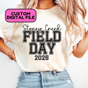 Puede incluir: Una camiseta blanca con texto negro que dice "Stoney Creek FIELD DAY 2025".